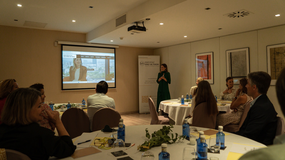 Mary Paz Díaz de Rada dando una charla en un evento con proyección y asistentes